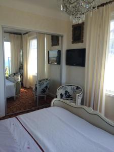een slaapkamer met een bed, 2 stoelen en een spiegel bij Villa Erresiñolettean in Ciboure