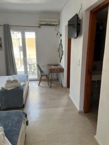 a room with two beds and a table and a balcony at Gardenia studios in Nydri