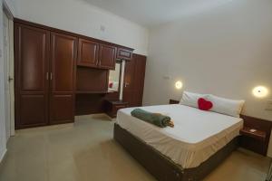 a bedroom with a large bed with a red pillow on it at Palm Beach View Resort Cherai in Cherai Beach