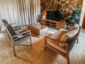 a living room with two chairs and a tv at Lekkerbly Self Catering in Pofadder