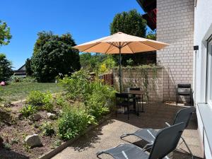 a patio with a table and chairs and an umbrella at Kappelblick Apartment ohne Küche - mehr als nur ein Doppelzimmer in Burgthann