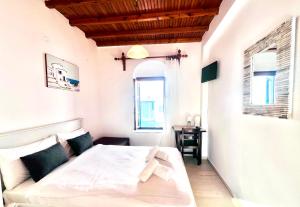 una camera da letto con un letto, una scrivania e due finestre di Studio Eleni a Mykonos Città