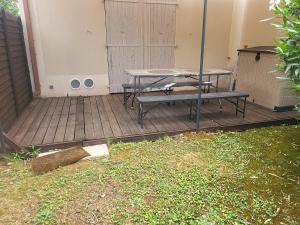 a picnic table and bench on a wooden deck at demeure du ventoux in Aubignan