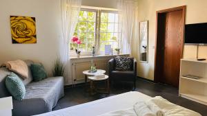 ein Wohnzimmer mit Sofa, Sessel und Fenster in der Unterkunft Staytopus Pension - Heidepark, Kartbahn, Sauna ink, Garden, BBQ in Schneverdingen