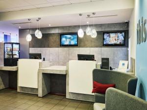 a waiting area of a restaurant with chairs and tables at ibis Hotel Düsseldorf Hauptbahnhof in Düsseldorf
