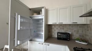 a kitchen with white cabinets and a refrigerator at La Casa di Katia in Pisa
