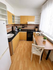 a kitchen with a wooden table and a wooden floor at Apartman Anna in Závada