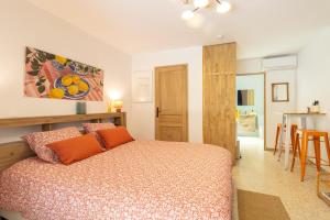 a bedroom with a bed with orange pillows at Studio La Provençale in Avignon