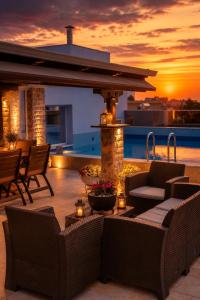 a patio with furniture and a sunset in the background at Luxury Penthouse with private pool in Preveza