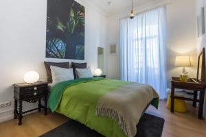 a bedroom with a green bed and a desk at House Sao Bento in Lisbon