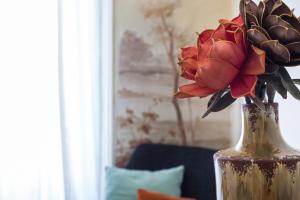 a vase filled with red flowers sitting on a table at House Sao Bento in Lisbon