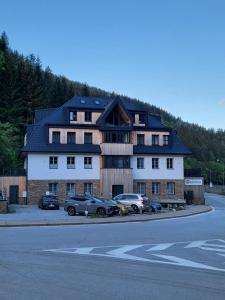 a large house with cars parked in front of it at PEC 140 - apartmány Máj in Pec pod Sněžkou