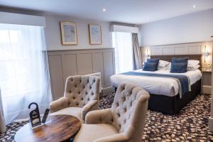 a hotel room with a bed and a table and chairs at Allerdale Court Hotel in Cockermouth