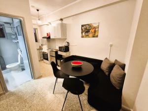 a living room with a black couch and a table at Lilia-RentalApartments in Vrachati