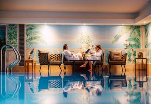 two women sitting in chairs in front of a swimming pool at Kertess in Sankt Anton am Arlberg +70 photos