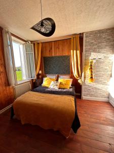 a bedroom with a large bed with yellow pillows at La chambre magique in Masseret