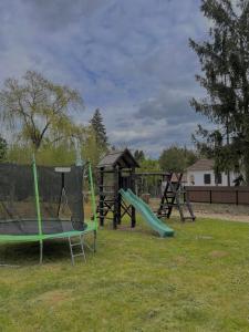 three swings and a slide in a playground at Gém Home Vendégház in Bodony
