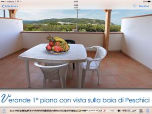 ペスキチにあるResidence AlaMarinaのバルコニーにテーブルとフルーツの盛り合わせ
