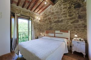 ein Schlafzimmer mit einem Bett und einer Steinwand in der Unterkunft Agriturismo Antico Corniolo - Gradoli - Lago di Bolsena in Gradoli