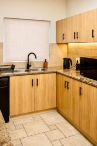 a kitchen with wooden cabinets and a sink at 2 at Sunset View in Langstrand