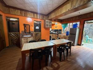 a kitchen with a table and chairs and a refrigerator at Sagada Pinewood Lodge basement in Sagada +19 photos