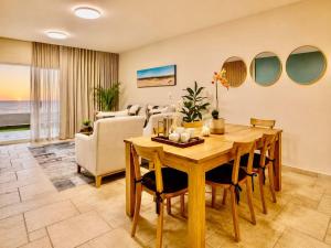 a dining room with a table and a living room at 2 at Sunset View in Langstrand