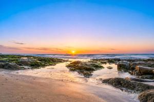 a beach with the sun setting over the ocean at 2 at Sunset View in Langstrand +20 photos