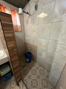 a shower with a glass door in a bathroom at Sagada Pinewood Lodge basement in Sagada