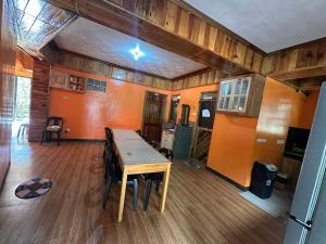 a large room with a wooden table and a kitchen at Sagada Pinewood Lodge basement in Sagada