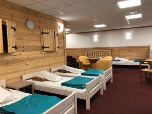 a room with four beds and a clock on the wall at Alpenrose Chamonix in Chamonix