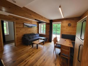 a living room with a couch and a table at PEC 140 - apartmány Máj in Pec pod Sněžkou