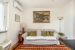 a living room with a white couch with green pillows at Santarem Terrace by Homing in Santarém