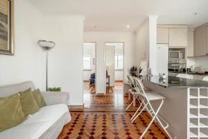 a living room with a white couch and a kitchen at Santarem Terrace by Homing in Santarém