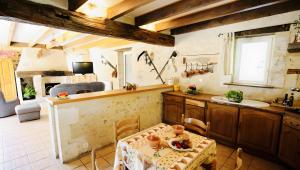 a kitchen with a table and a sink in a room at Seul au Monde in Guizengeard