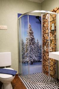 a bathroom with a shower with a picture of a tree at Hotel am Kurpark in Bad Lauterberg +50 photos