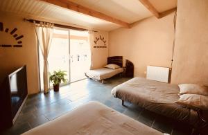 a bedroom with two beds and a tv and a window at Seul au Monde in Guizengeard