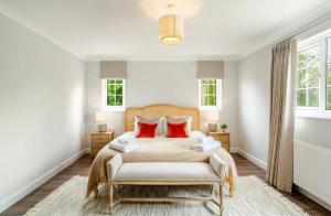 a bedroom with a bed and two windows at Dalforth Thaxted Barn Collection in London Stansted Airport