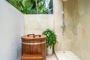 a shower with a wooden barrel in a bathroom at Sunny Muse by Betterplace in Canggu +39 photos