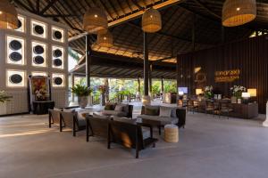 a lobby with couches and chairs in a building at ananea Beyond Khaolak in Khao Lak