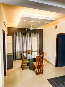 a dining room with a glass table and chairs at Grand Retreat in Trichūr