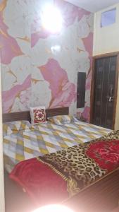 a bedroom with a large bed with a painted wall at Braj Pushp Guest House in Mathura