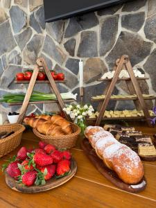 a table topped with different types of bread and pastries at Pensiunea Maramures Guesthouse in Vişeu de Jos
