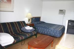 
a living room with a couch, coffee table and a television at Kingsbridge Inn / Bon-Air Motel in Wasaga Beach
