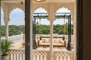a porch with a couch on a swing at Hotel Amarsar Palace in Amarsar