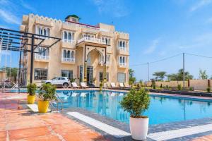 a hotel with a swimming pool in front of a building at Hotel Amarsar Palace in Amarsar
