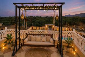 a porch with a couch on a balcony with lights at Hotel Amarsar Palace in Amarsar
