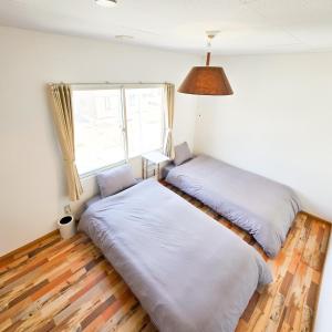 two beds in a room with a window at Snow Veil Iwamizawa in Iwamizawa +58 photos