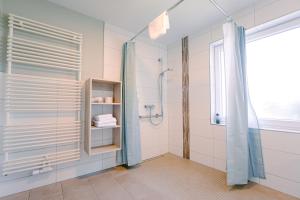 a bathroom with a shower and a glass door at Hotel Waastwinj in Utersum +66 photos