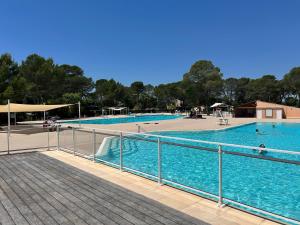 a large swimming pool with people in the water at Soucado in Fréjus