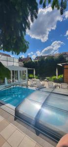a large swimming pool with chairs and a building at Hotel am Gutspark Berthold Andre und Ursula Prager GbR in Leipzig